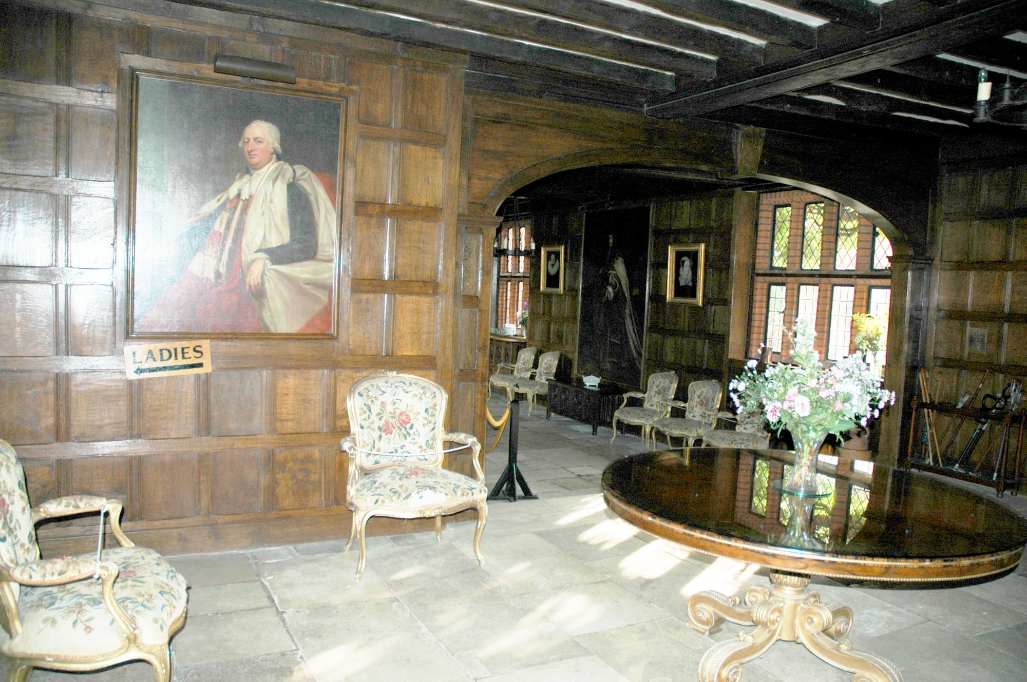 An oak panelled room hung with portraits