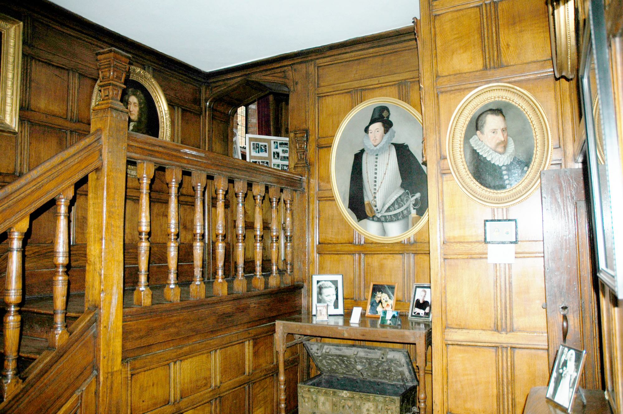 The oak staircase, hung with portraits